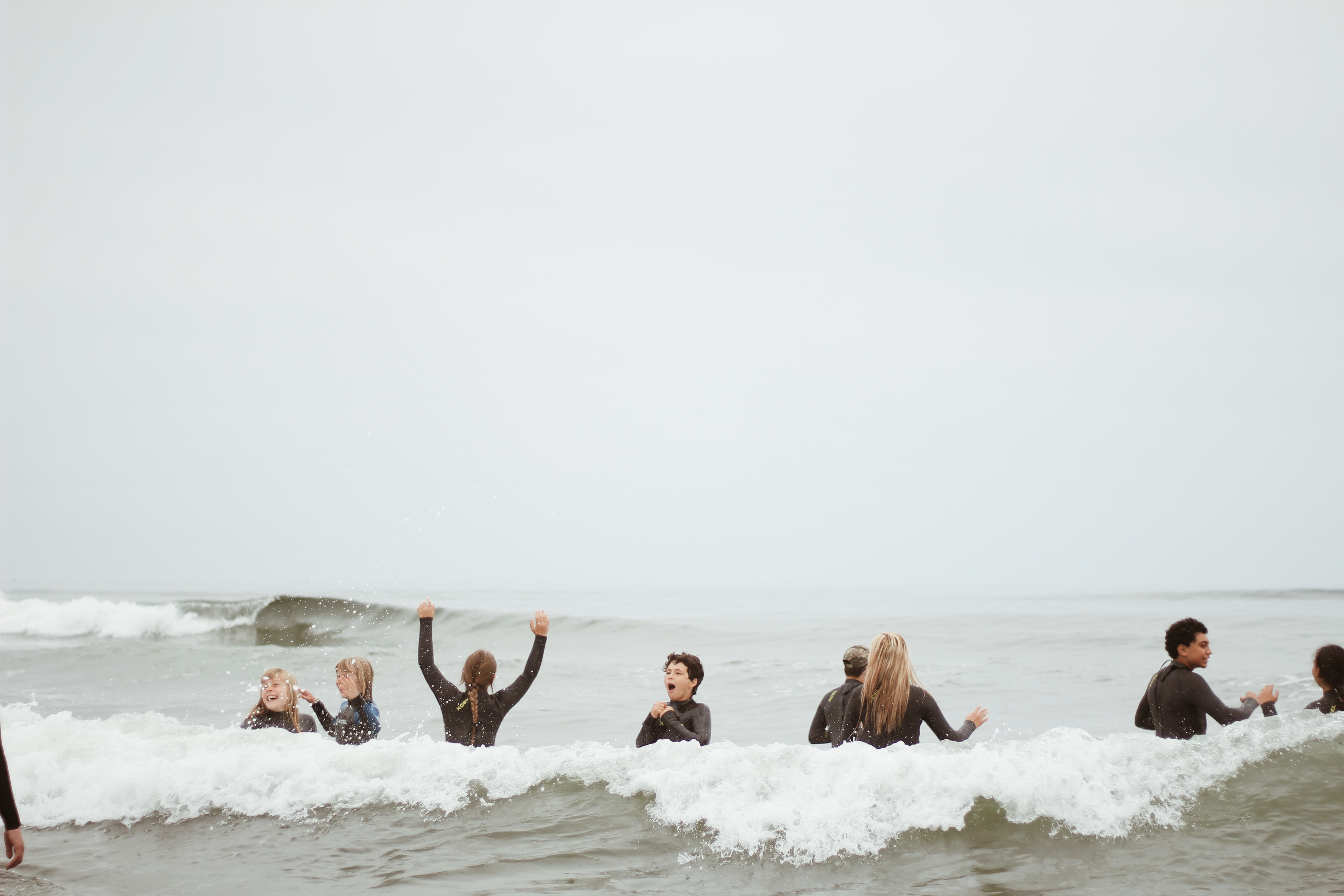 kids playing in the surf at a youth surf camp